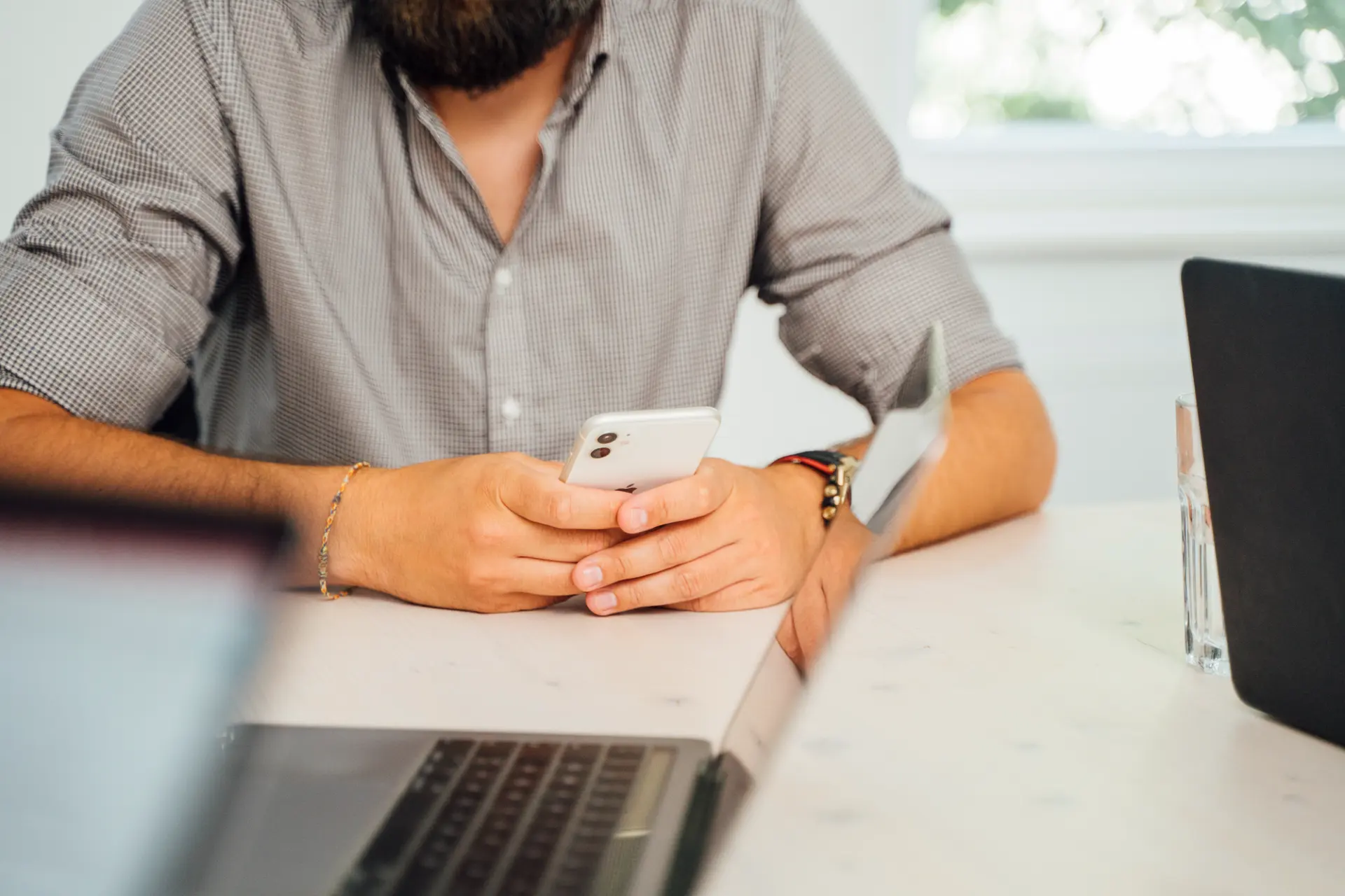 Social-Media-Management am Smartphone neben Laptop und Tablet